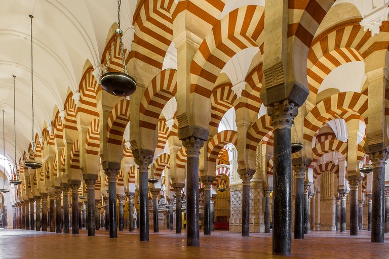 A low angle shot of patterned columns lined up inside a majestic cathedral in Spain